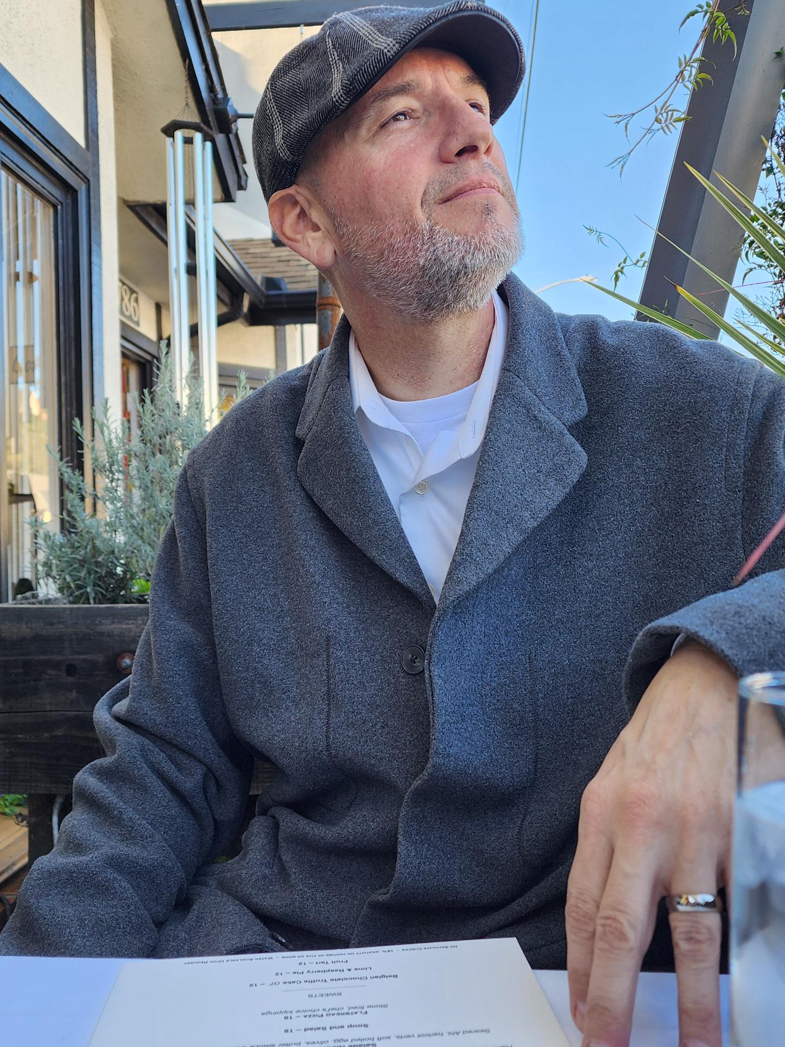 Gregory wearing his cap and wedding-day suit at our dinner table