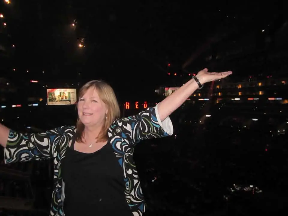 Karen smiling with her arms open at a live event