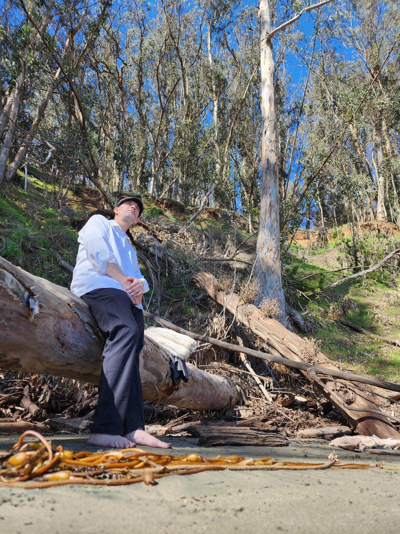 Gregory standing beside fallen trees in our wedding cove