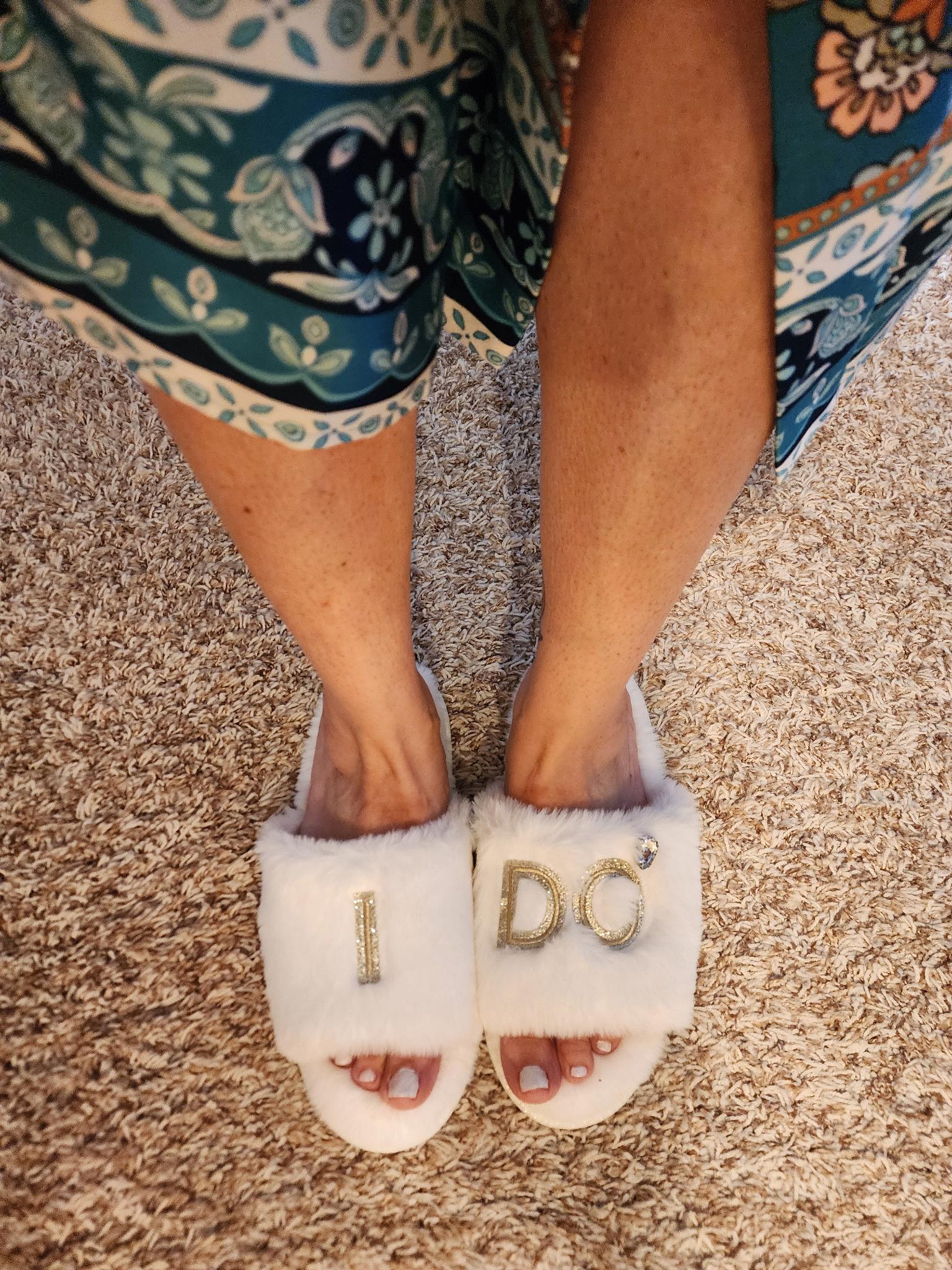 Andie’s white wedding slippers with I DO in gold lettering