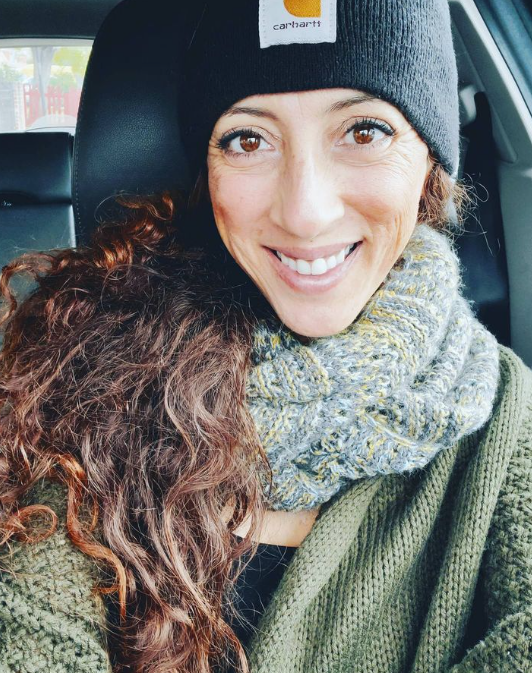 Andie Kat smiling in a knit hat and scarf