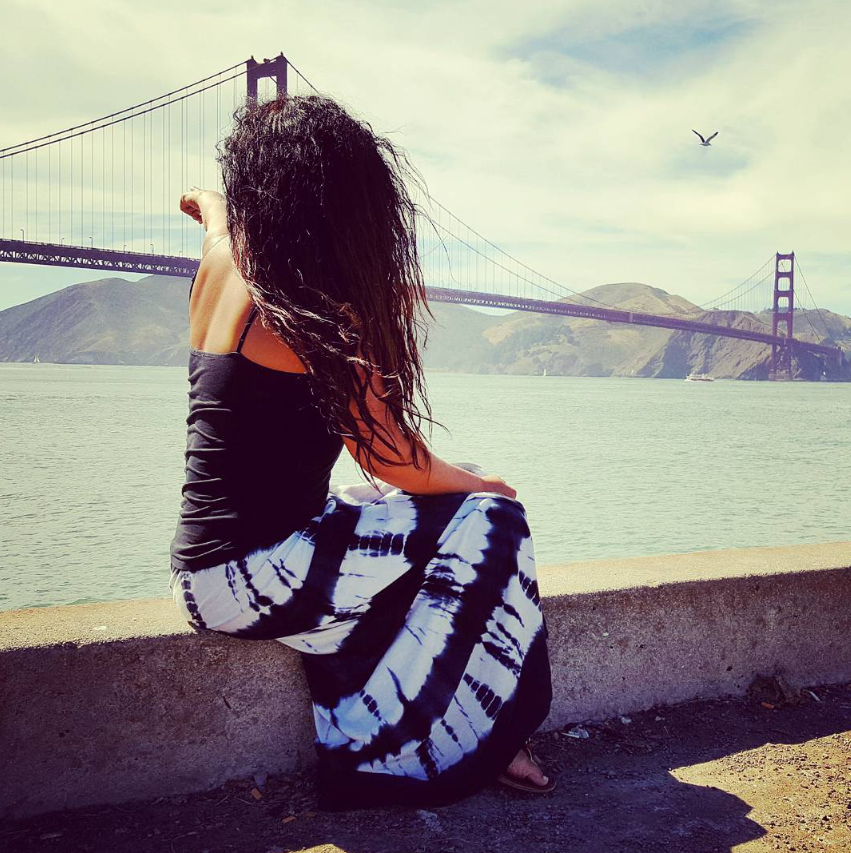 Andie sitting beside the bay with the Golden Gate Bridge behind her