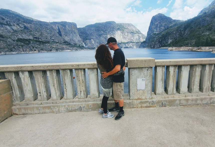 Andie and Gregory, her SEAHUBBY, sharing a kiss beside the water