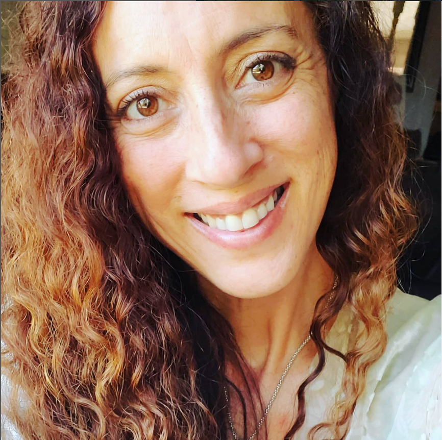 Andie Kat smiling, with her natural curls framing her face