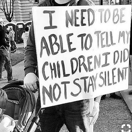 Black-and-white photograph of a protest sign reading: I need to be able to tell my children I did not stay silent
