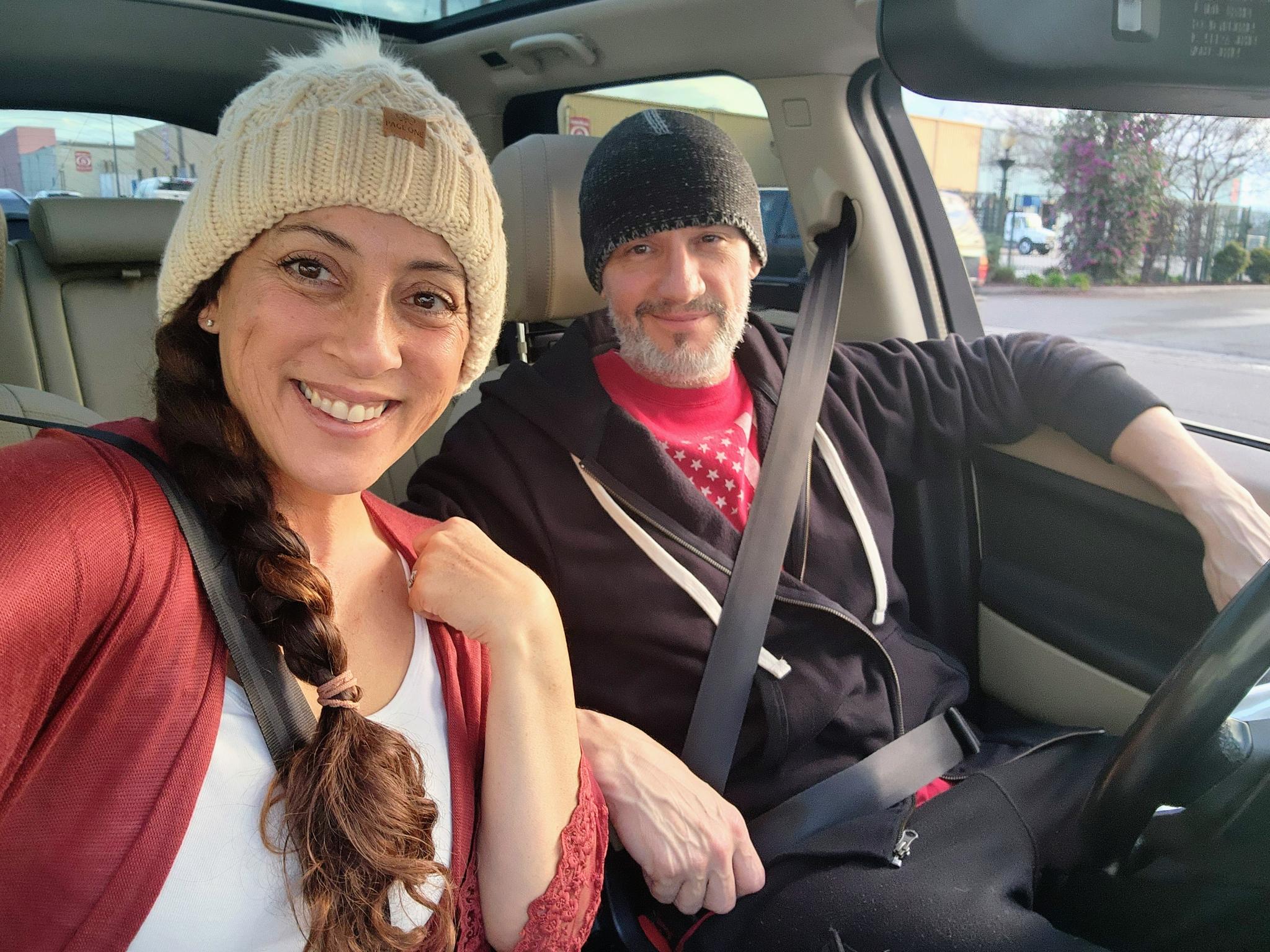 Andie and Greg smiling together in the car