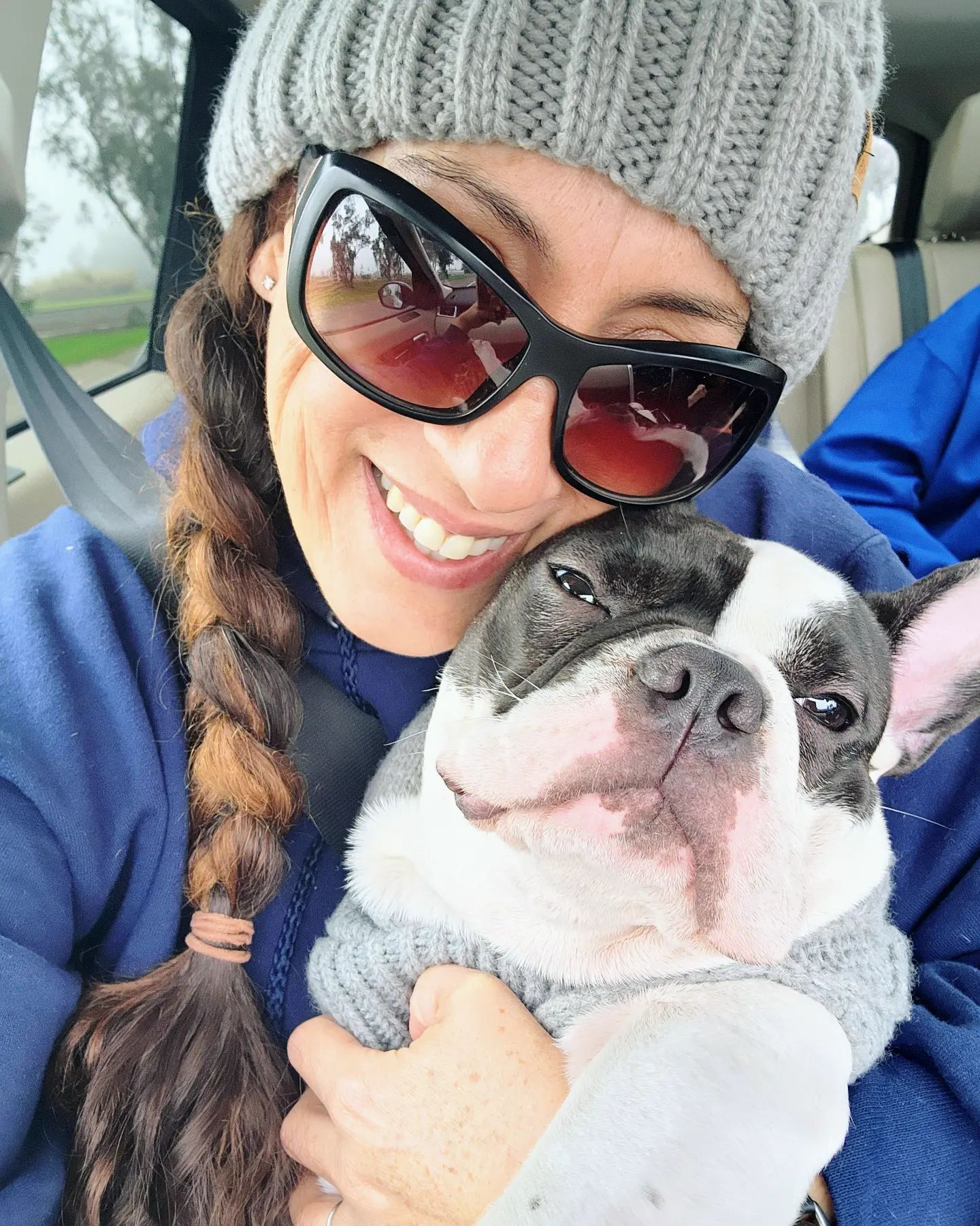 Andie holding Piper while bundled up in the car