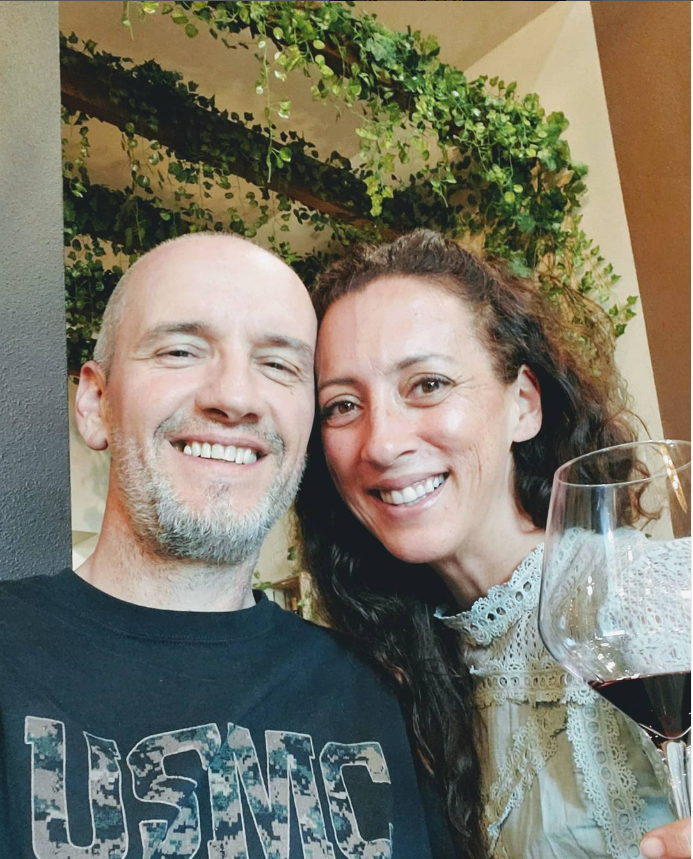 Andie and Greg smiling together at dinner