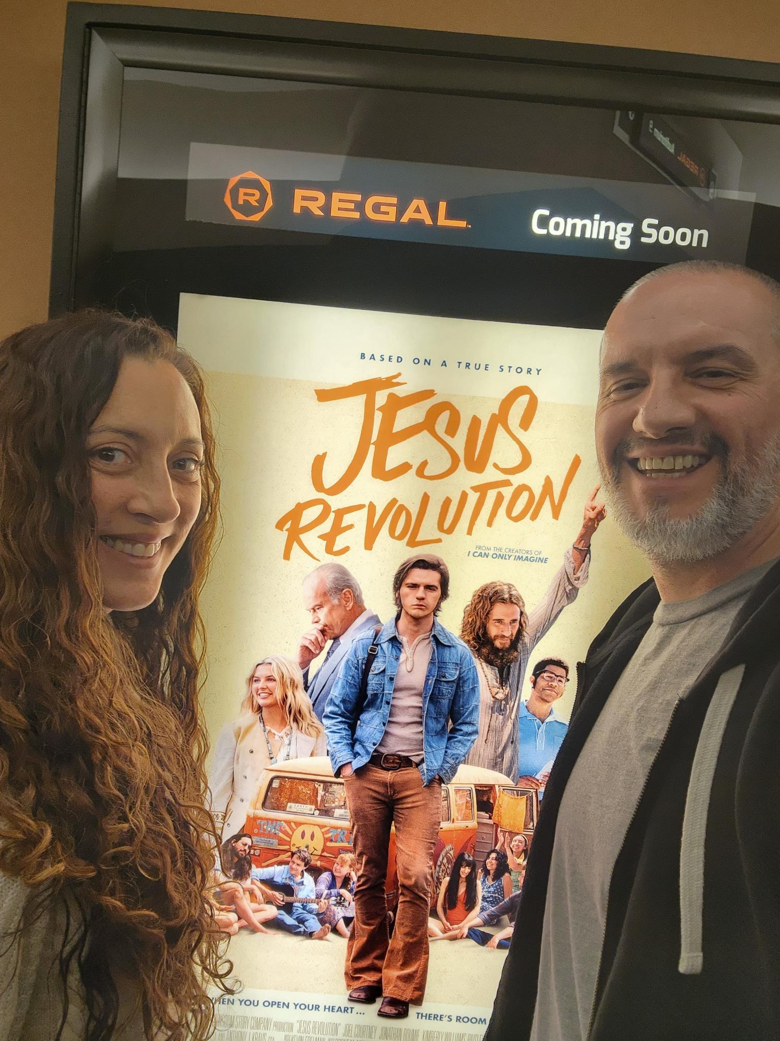 Andie and Gregory beside a Jesus Revolution movie display