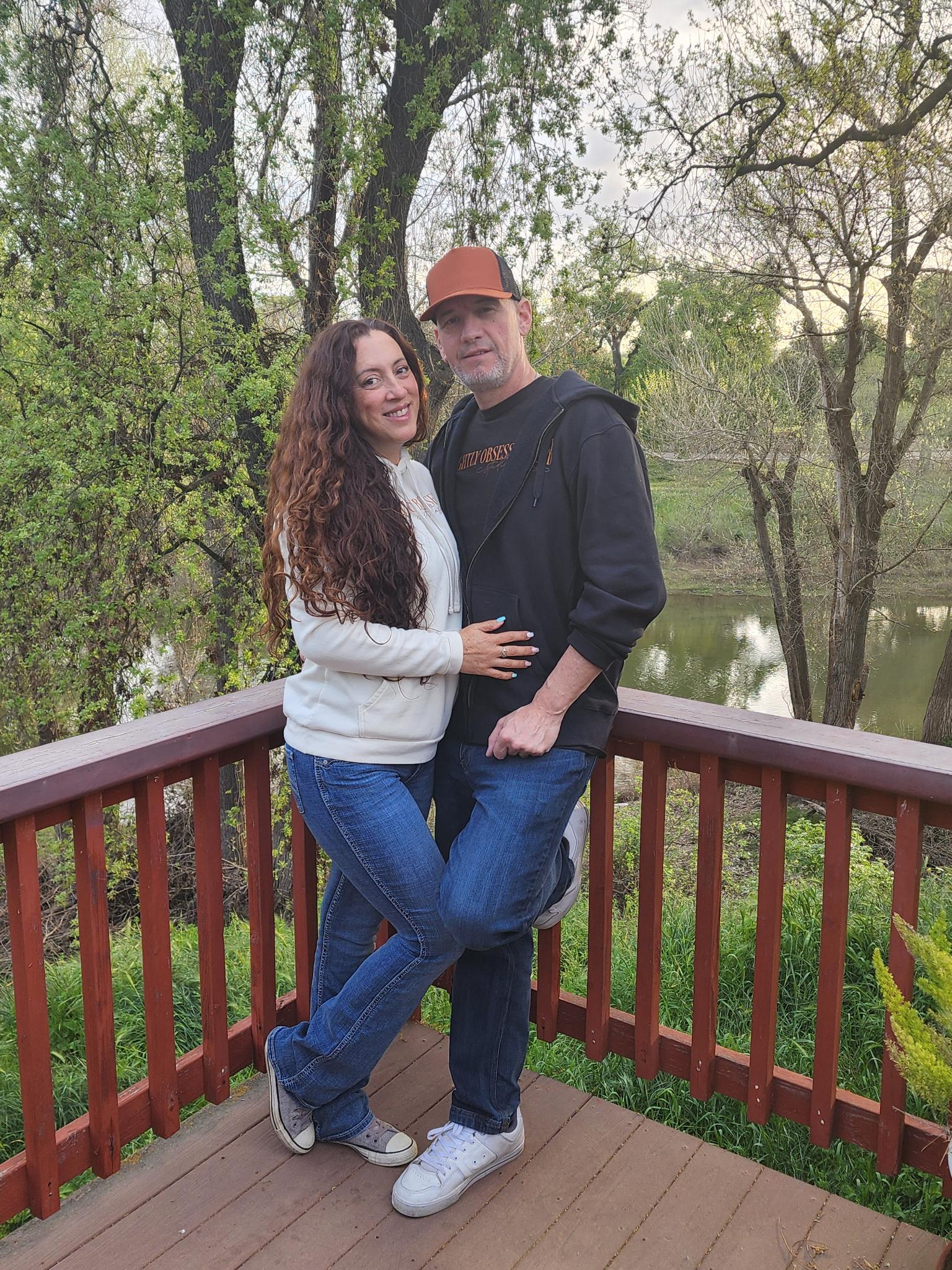 Andie and Gregory together on the deck above the river